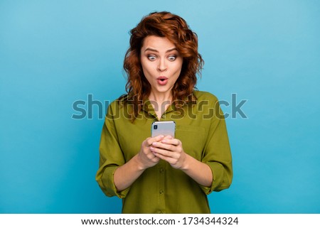 Portrait of astonished crazy woman use smartphone impressed social media information stare stupor screen wear good look clothes isolated over blue color background