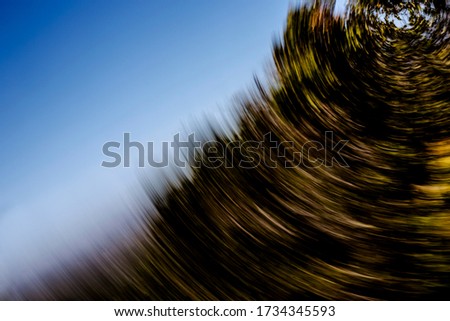 Mountain of spiralling vegetation under blue sky psychedelic abstract motion blurred background texture