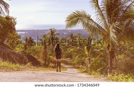 Tourist walking with the backpack in the jungle forest. Young women with the backpack. Travellers bag in the palm trees forest.
