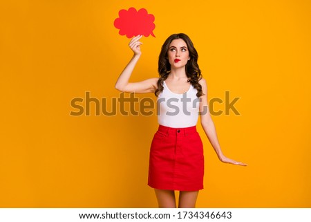 Photo of pretty cheerful lady hold big paper mind cloud interested look up empty space biting lips cunning wear white casual tank-top red short skirt isolated yellow color background