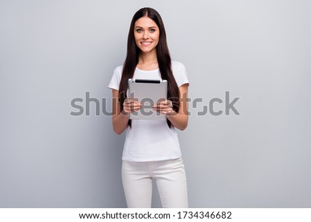Portrait of her she nice attractive lovely pretty charming cheerful cheery straight-haired girl holding in hands using digital gadget isolated over light gray pastel color background
