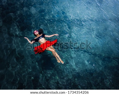 Aerial view of a beautiful woman dancing  in the sea 