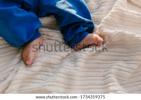 Children's legs. Baby's little legs. The baby lies barefoot.