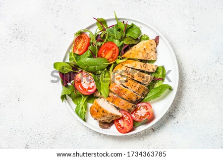 Chicken fillet with salad at white table. Healthy food, keto diet, diet lunch concept. Top view. Royalty-Free Stock Photo #1734363785