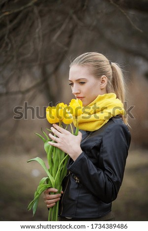 Girl with a bouquet of tulips. Photo taken with selective focus and noise effect.