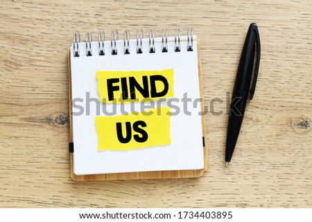 FIND US text written in an office notebook on a wooden table. Business concept.