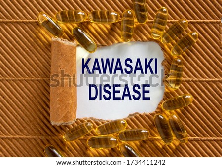 The text 'kawasaki disease' appearing behind torn brown paper. Yellow pills. Concept. Beautiful background.