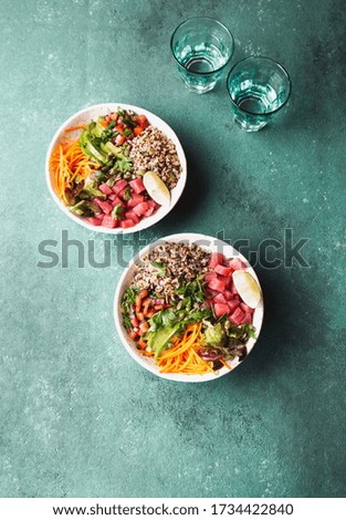Vercion of Hawaiian tuna poke bowl with quinoa. tropical background.