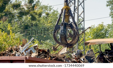 Photo of metal claw lifting metal on scrapyard Royalty-Free Stock Photo #1734440069