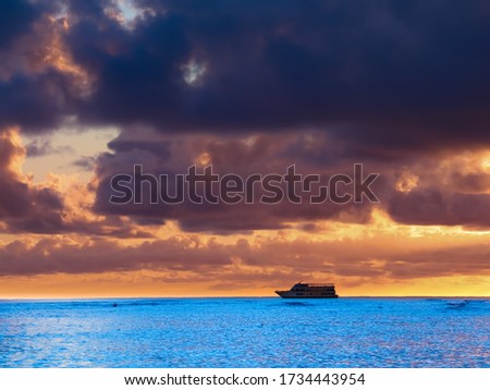 Panoramic View of a beautiful Sunset on Waikiki Beach Honolulu Hawaii with blue waters and grey cloudy skies