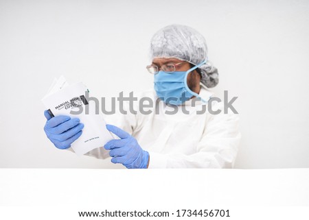 Doctor reading a Medical Book of novel coronavirus in office desk. Coronavirus Research concept  