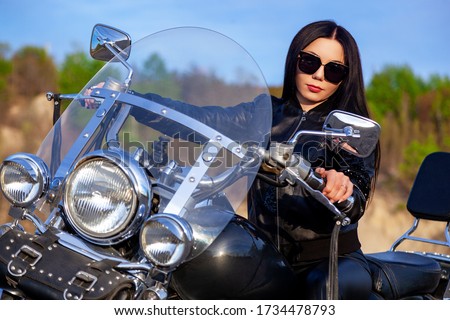 young woman sitting on motorcycle. biker girl posing on bike.