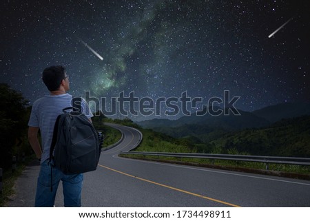 
Male tourists Asian Backpack Travel on mountain road Stand alone at the stars and the Milky Way For the ultimate goal of success. Long exposure with grain.