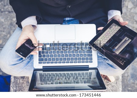 close up multitasking man using tablet, laptop and cellphone connecting wifi in the city street urban Royalty-Free Stock Photo #173451446
