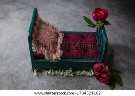 the wooden bed is decorated with red peonies. props for newborn photo sessions. red peonies. background texture