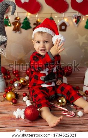 a little boy tries to take off Santa's Christmas hat . new year. a child on Christmas morning