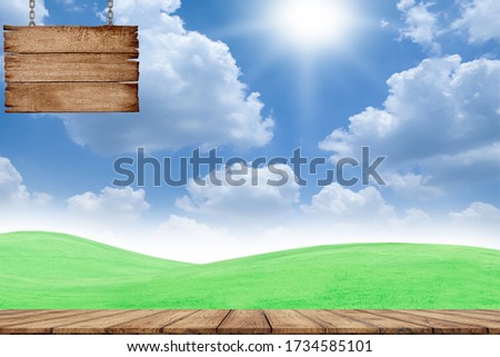 Wooden board and wooden sign hanging with a chain on-field and sky background