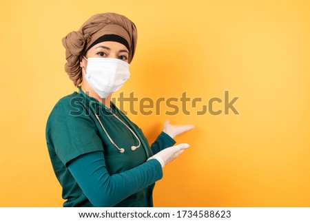 Young beautiful Arab doctor woman over isolated background Inviting to enter smiling natural with open hands. Welcome sign.