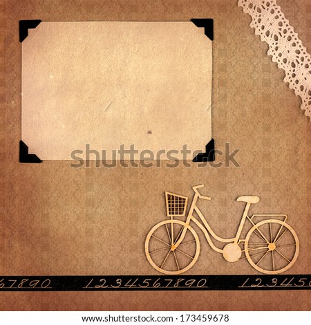 Page from a retro-styled photo album with blank photo frame and scrap bicycle