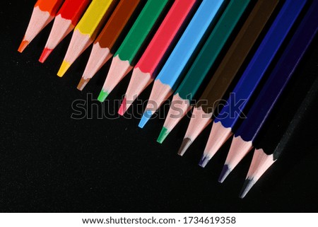 Colored pencils viewed from above diagonally on black background