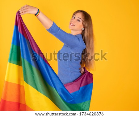 pretty blonde lesbian girl with gay pride flag on pastel yellow background