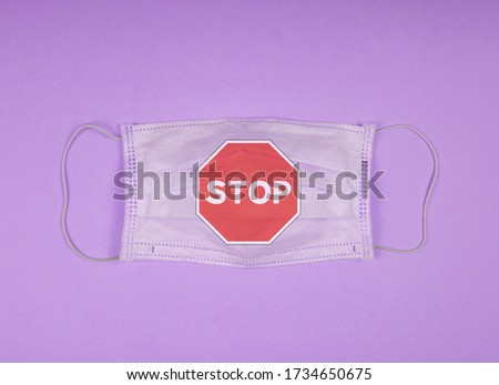 Surgical mask with rubber ear straps. Typical 3-ply surgical mask to cover the mouth and nose. Procedure mask from bacteria. Protection concept. Covid 19  masks. Coronavirus. stop covid 19 sign