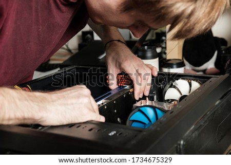 Man repairs a computer system unit, changes parts, video card and hard drive. Computer Repair Wizard.