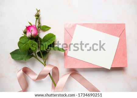 postcard mockup. a small bouquet of pink roses and an envelope. space for text. invitation. congratulation. flat lay