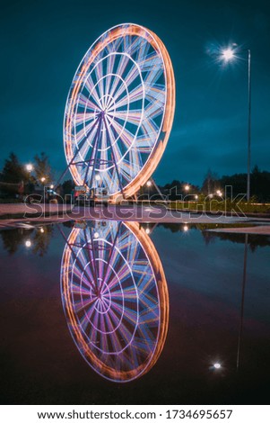 evening view of the ferris wheel and reflection in a puddle