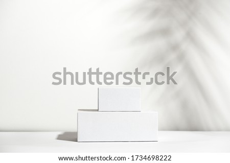 White empty stands on light shadow background. Blank unbranded shopfront. Showcase for cosmetic products. Product advertisement. Copy space. Cosmetology and beauty concept Royalty-Free Stock Photo #1734698222