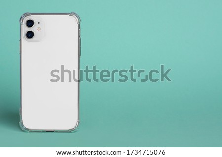 White iPhone 11 in clear silicone case back view. iPhone 12 case mockup isolated on green background. Banner with place for text on the right