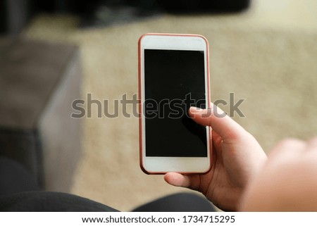 Close up of woman reading news on smart phone at home. Hands texting message or scrolling on social media. Browsing internet, chatting online
