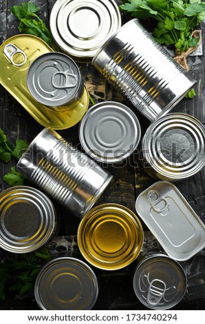 Food in tin cans on black background. Food stocks. Top view.