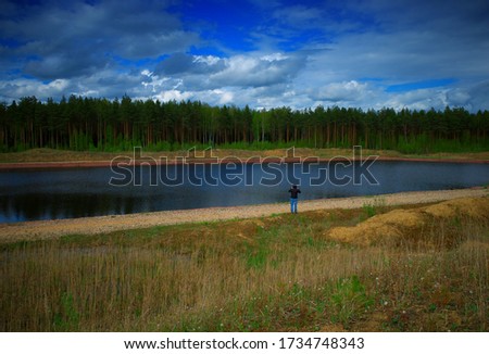 Man taking pictures of summer river background