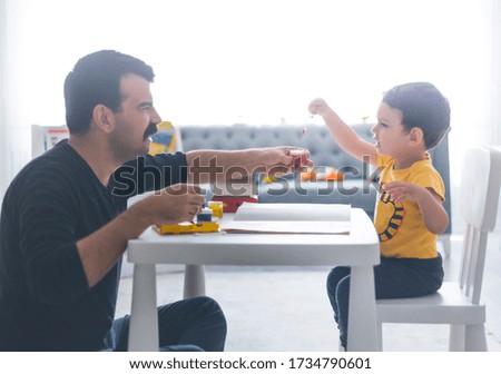 Happy father and his son fun together during finger paint activity, Turkish family