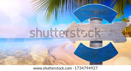 Hawaii summer vacation concept; beach signboard on tropical seashore background

