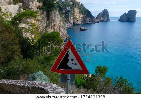 Landslide danger sign and seaview from Via Krupp - paved footpath on the island of Capri, Italy.