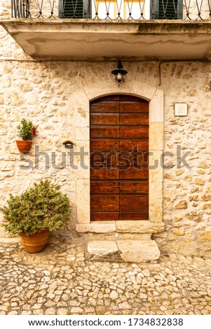 traditional medieval wooden door and entrance to a stone house in an old italian town