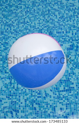A colorful ball floating in a blue swimming pool