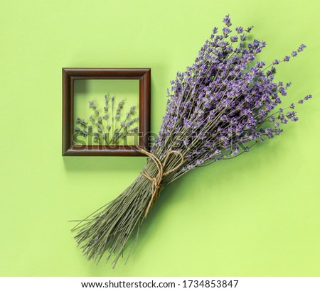 Wooden frames with  beautiful bouquet of fragrant lavender in  rustic style for gift on green wall. Holiday party decoration. Vintage floral card. Interior concept.