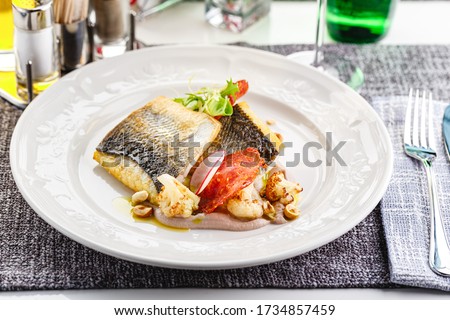 Pike perch fillet with chorizo, cauliflower and radish in a restaurant serving Royalty-Free Stock Photo #1734857459