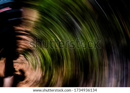 Earthy vortex of sand, vegetation and silhouette - rotational abstract motion blurred background, texture