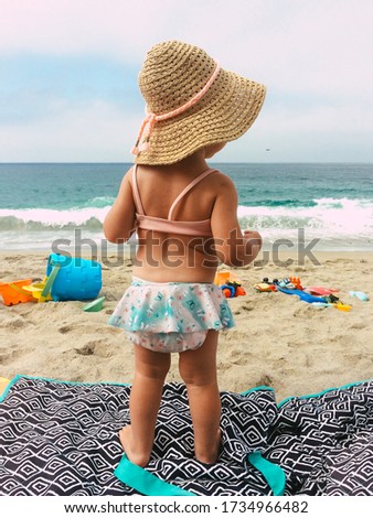 Toddler Girl in bikini at a sunny beach in California during a hot summer day