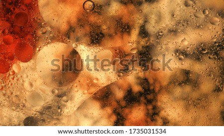 Mixing water and oil, beautiful colors. Orange light. Close-up. Abstract macro background. Water and oil bubbles. Abstract light illumination