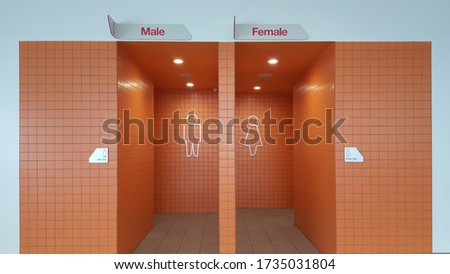 View of the lady and gentlemen's public toilet or bathroom entrance with bright orange tiles.