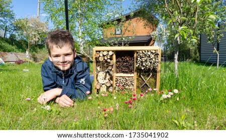 Cute boy made an insect house or a dormitory for bugs and beetles to protect the environment in the garden. Ideas of summer activities for kids. Activities for children on vacation. DIY insect hotel. Royalty-Free Stock Photo #1735041902
