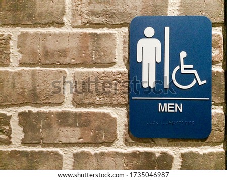 Men restroom blue white sign handicapped pictogram symbol on brick wall