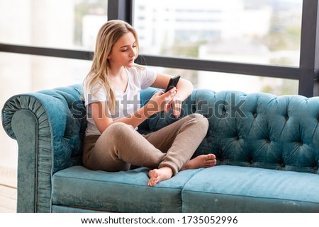 Teenage girl studying with her smartphone at home during quarantine isolation during coronavirus pandemic. Stay at home concept Royalty-Free Stock Photo #1735052996