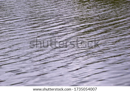 Texture of reflection of the surface of the water on a forest lake