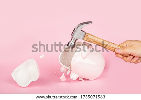 Men's hand smashes with a hammer Piggy bank on pink background. mockup, template. Concept of financial crisis after coronavirus covid-19 pandemic